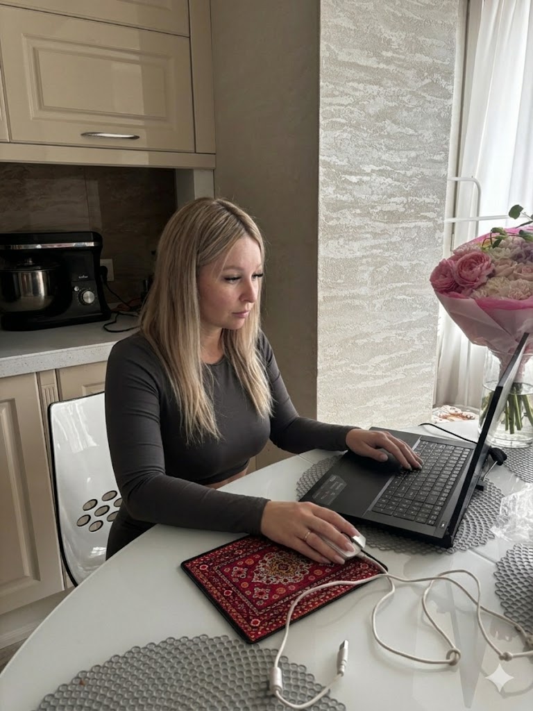 Кристина работает за ноутбуком дома